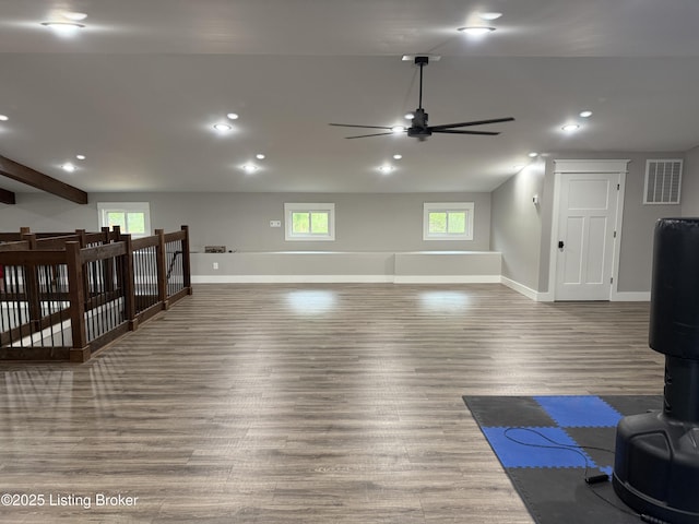 workout area featuring wood finished floors, visible vents, a healthy amount of sunlight, and a ceiling fan