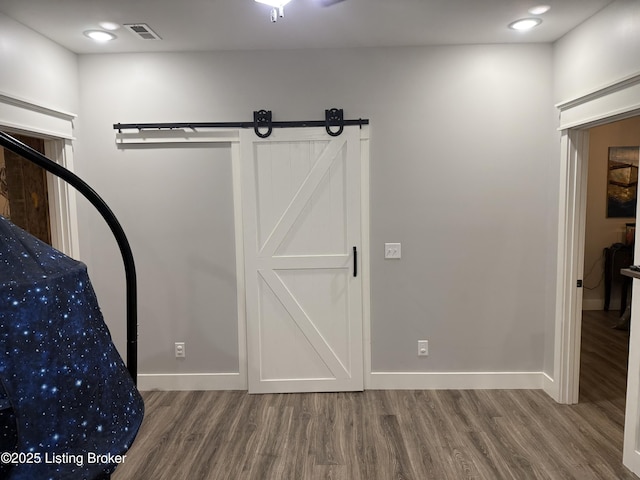 interior space with wood finished floors, visible vents, and baseboards