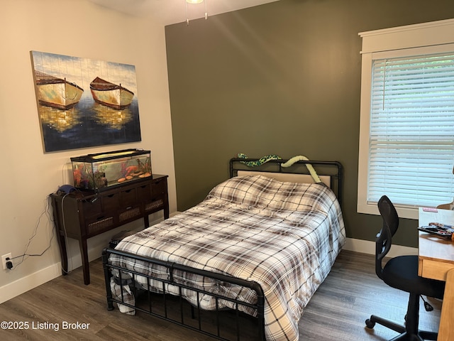 bedroom featuring wood finished floors and baseboards