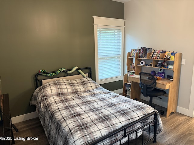 bedroom with wood finished floors and baseboards