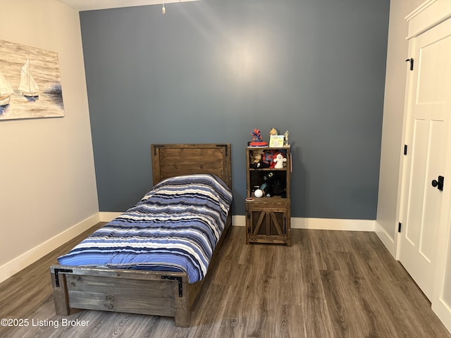 bedroom with wood finished floors and baseboards