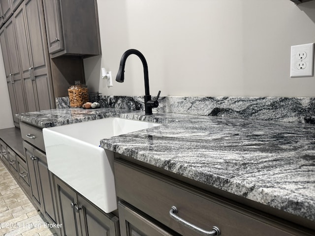 interior space with dark stone countertops and a sink