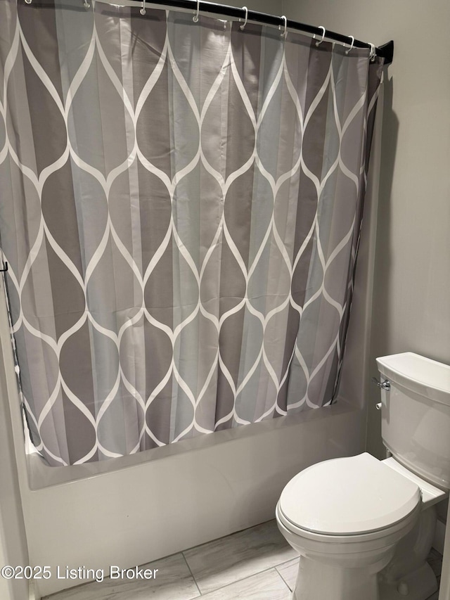 bathroom featuring toilet and shower / tub combo with curtain
