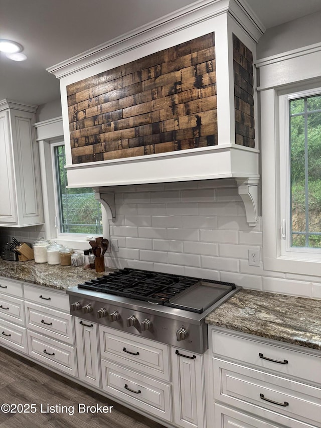 kitchen featuring stone countertops, stainless steel gas stovetop, decorative backsplash, and white cabinetry