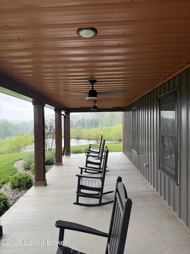 view of patio featuring a ceiling fan and a water view
