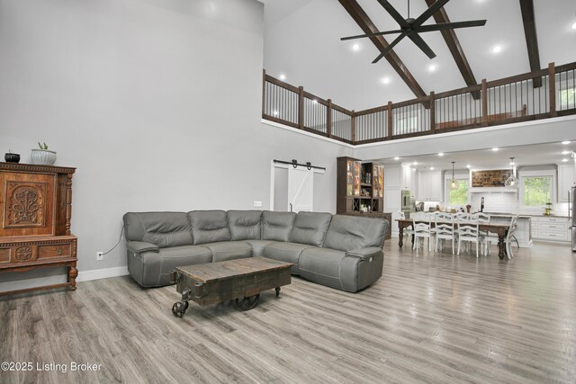 501 Shumate Ln, Bardstown, KY 40004 - living area featuring a barn door, high vaulted ceiling, ceiling fan, light wood-style flooring, and baseboards