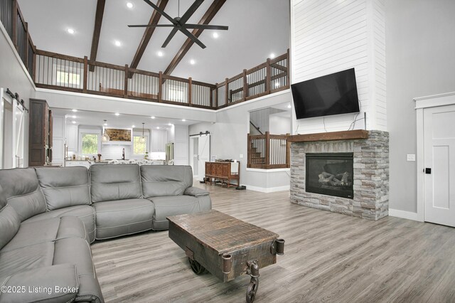 501 Shumate Ln, Bardstown, KY 40004 - living room with high vaulted ceiling, a barn door, ceiling fan, light wood finished floors, and a stone fireplace