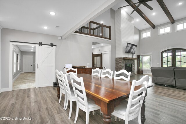 501 Shumate Ln, Bardstown, KY 40004 - dining room with a barn door, wood finished floors, a ceiling fan, beam ceiling, and a stone fireplace