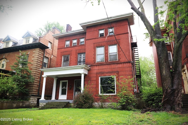 view of front of home featuring a porch, a front yard, and brick siding