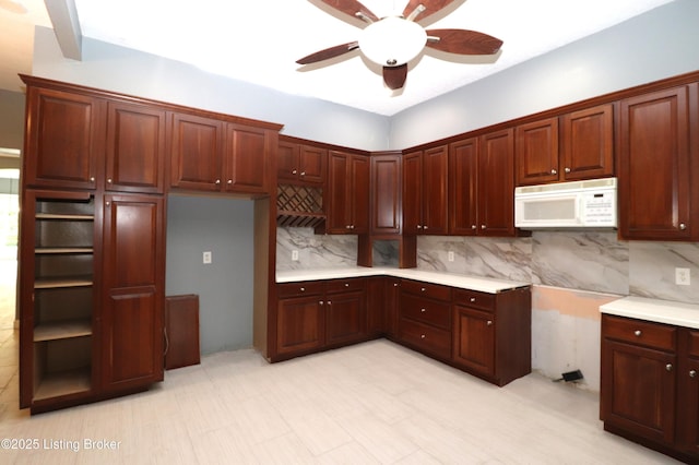 kitchen with ceiling fan, decorative backsplash, white microwave, and light countertops