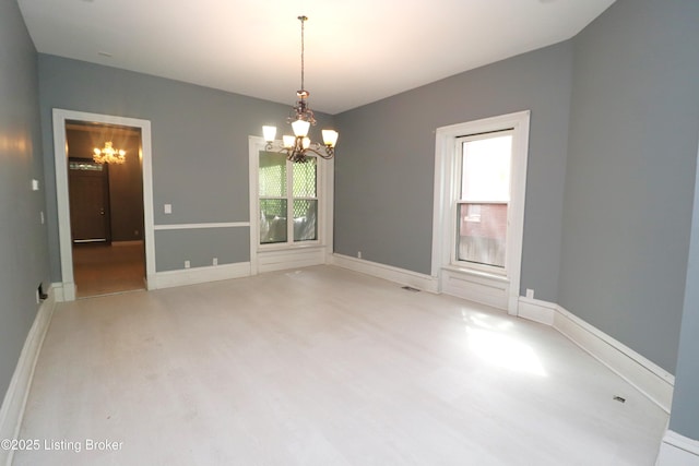 unfurnished room with light wood-style flooring, visible vents, a notable chandelier, and baseboards
