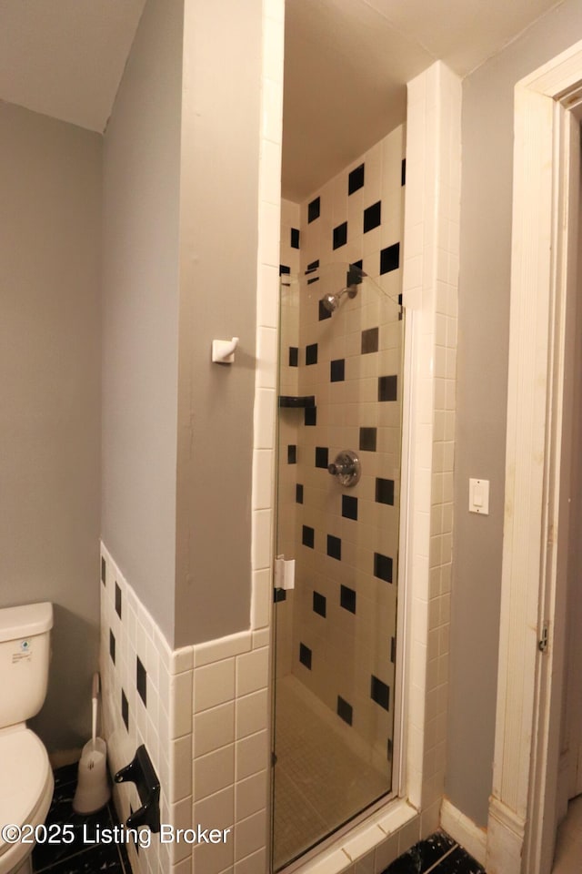 full bathroom featuring a stall shower and toilet