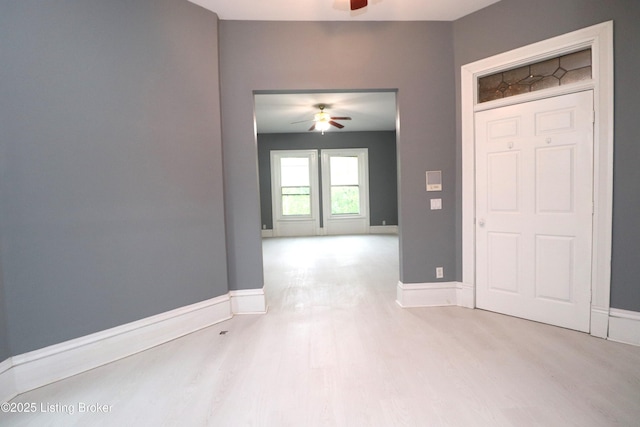 unfurnished room featuring ceiling fan, wood finished floors, and baseboards