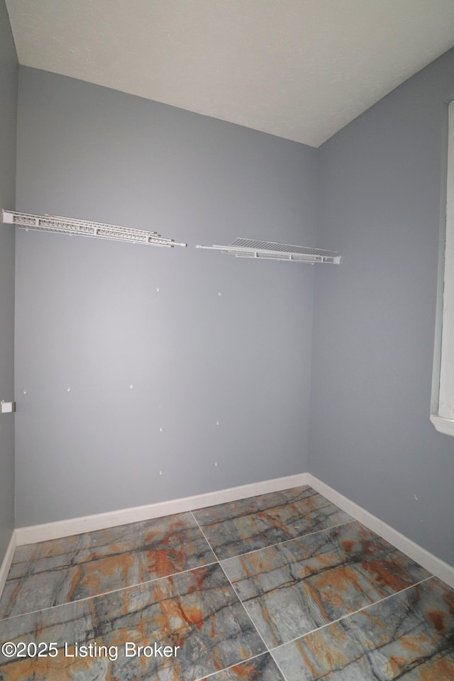 interior space featuring stone finish floor and baseboards