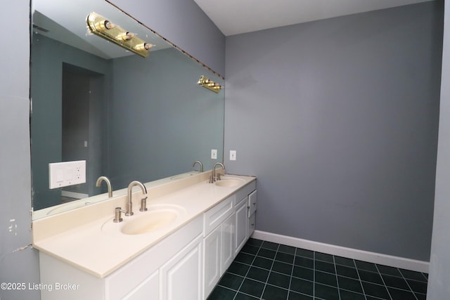 bathroom featuring double vanity, a sink, tile patterned floors, and baseboards