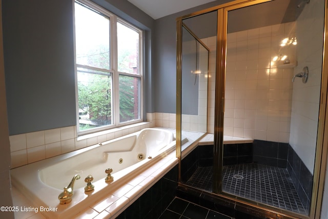 bathroom with a tub with jets, a shower stall, and tile patterned flooring