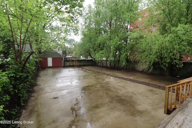view of patio featuring a storage unit, a fenced backyard, and an outdoor structure