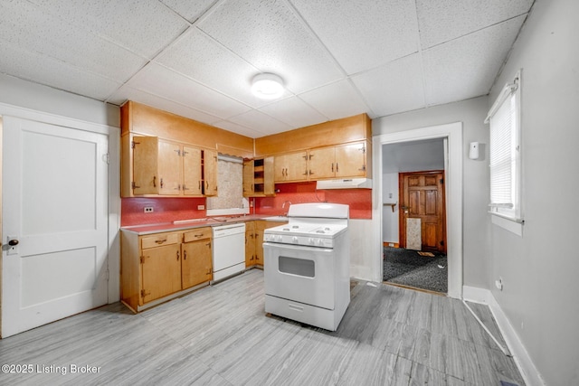 kitchen featuring a paneled ceiling, baseboards, under cabinet range hood, and white appliances