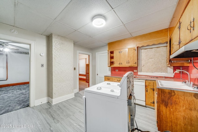laundry room featuring light wood-style flooring, a sink, baseboards, washer / dryer, and laundry area