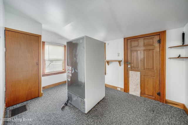 office space featuring visible vents, vaulted ceiling, carpet floors, and baseboards