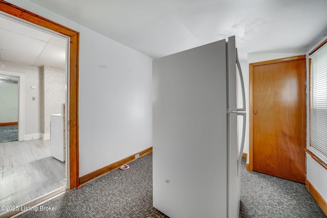 corridor with baseboards and carpet floors