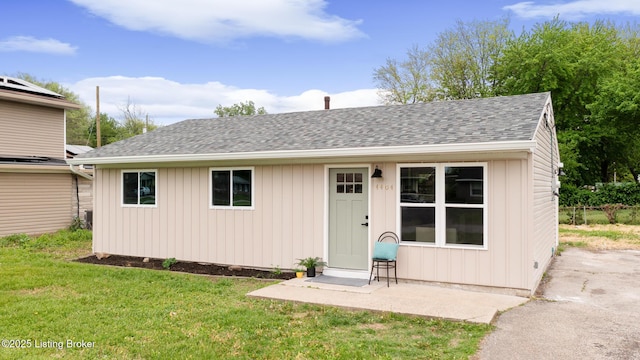 view of front of home featuring a shingled roof and a front yard