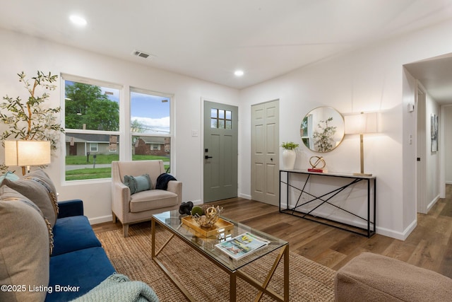 living room featuring baseboards, recessed lighting, wood finished floors, and visible vents