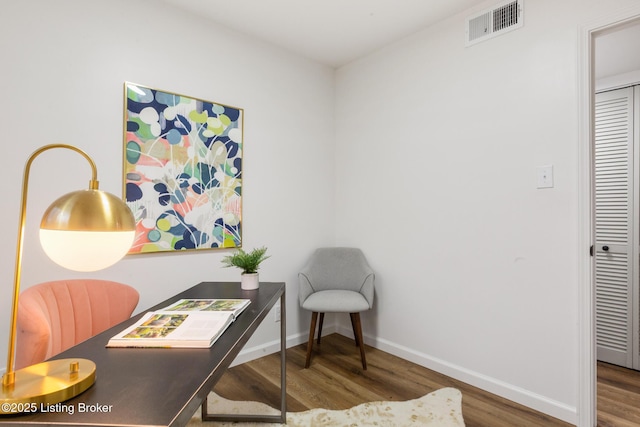 office area with baseboards, wood finished floors, and visible vents
