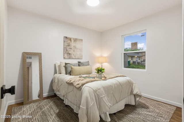 bedroom featuring baseboards and wood finished floors