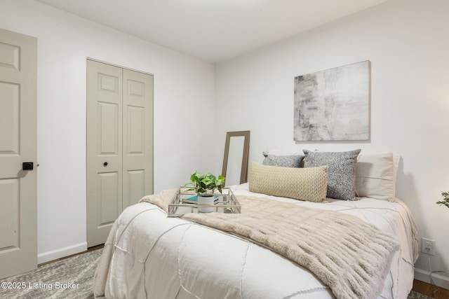 bedroom with baseboards, a closet, and wood finished floors