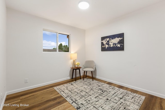 living area featuring baseboards and wood finished floors