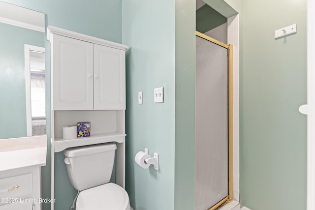 bathroom with a stall shower, toilet, and vanity