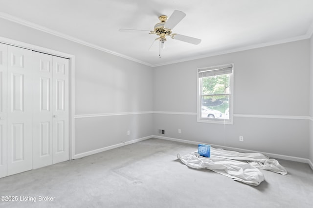 unfurnished room featuring baseboards, ornamental molding, ceiling fan, and carpet flooring