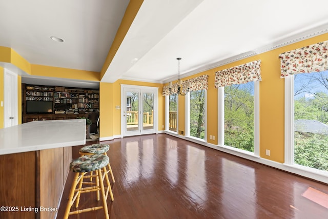 unfurnished dining area featuring dark wood-style floors, a chandelier, and baseboards