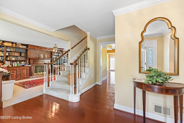 stairs with visible vents, baseboards, ornamental molding, wood finished floors, and a ceiling fan