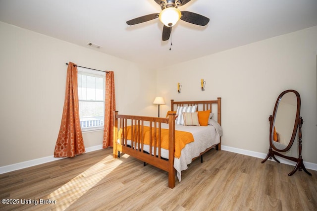 bedroom featuring visible vents, ceiling fan, wood finished floors, and baseboards