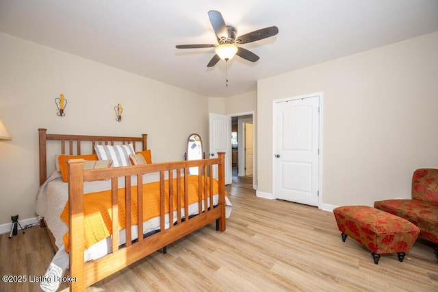 bedroom featuring baseboards, a ceiling fan, and light wood finished floors