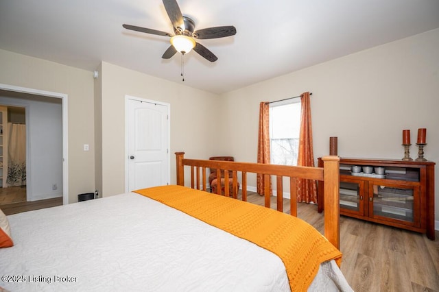 bedroom featuring ceiling fan, light wood finished floors, and baseboards
