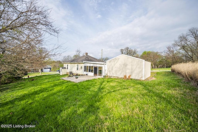 back of property with a lawn, a chimney, and a patio