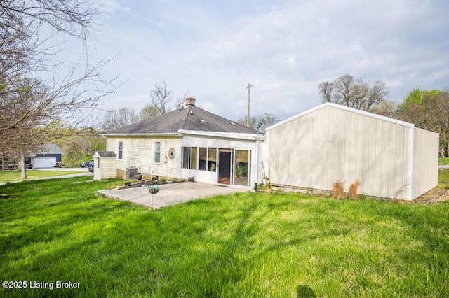 back of house featuring a lawn, a chimney, central air condition unit, and a patio area