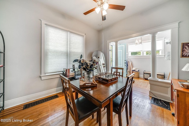 dining space with a ceiling fan, visible vents, wood finished floors, baseboards, and ornate columns
