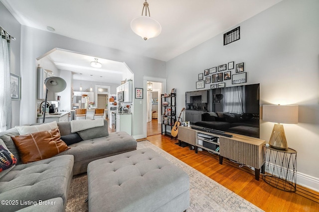 living room featuring baseboards, light wood finished floors, and visible vents