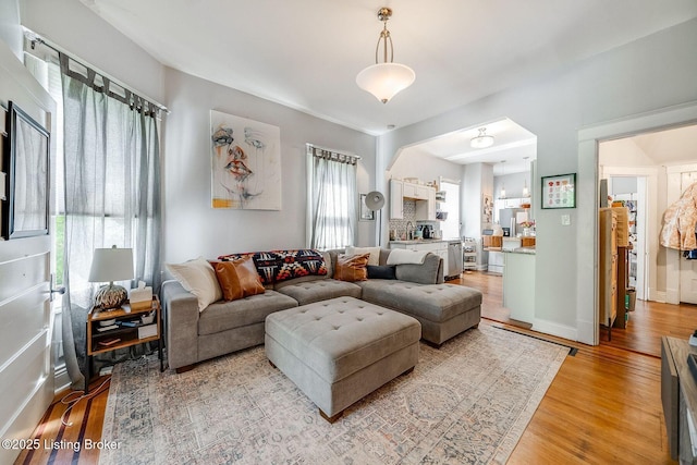 living area featuring baseboards and light wood-style flooring