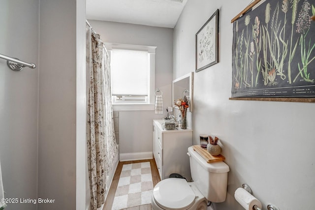 full bath featuring a shower with curtain, vanity, baseboards, tile patterned floors, and toilet