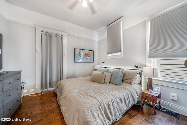 bedroom featuring dark wood-type flooring, a ceiling fan, and baseboards