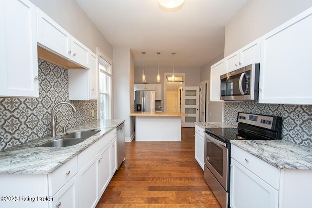 kitchen with decorative backsplash, appliances with stainless steel finishes, dark wood-style floors, and a sink