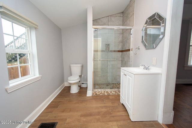bathroom featuring toilet, vaulted ceiling, visible vents, and a stall shower