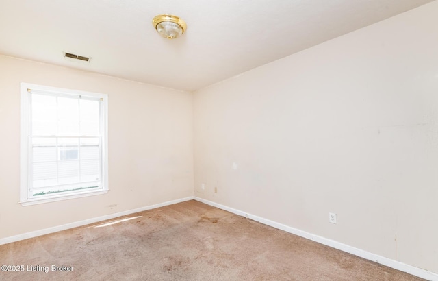 unfurnished room with baseboards, carpet flooring, and visible vents