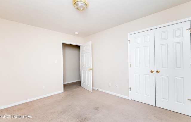 unfurnished bedroom featuring baseboards, carpet, and a closet