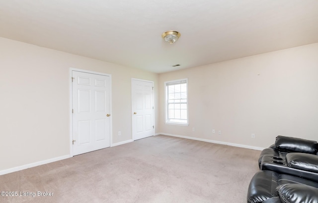 unfurnished room with baseboards and light carpet